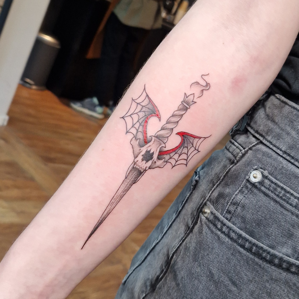 Dagger with skull and wings tattoo in illustrative blackwork